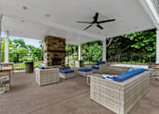 Thumbnail 15 of 30 - A patio with a white ceiling fan and blue cushions.