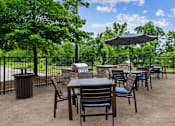 Thumbnail 18 of 30 - A patio with a table and chairs and an umbrella.