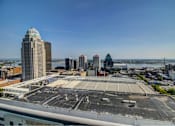 Thumbnail 4 of 18 - A cityscape with a large open parking lot in the foreground.