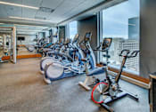 Thumbnail 10 of 18 - A gym with exercise bikes and a view of the city.