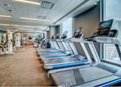 Thumbnail 12 of 18 - A gym with treadmills and other exercise equipment.