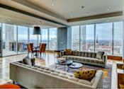 Thumbnail 13 of 18 - A modern living room with a large window overlooking the city.