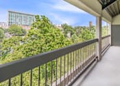 Thumbnail 24 of 25 - a balcony with a view of the city and trees
