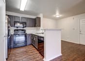 Thumbnail 3 of 23 - A kitchen with a white refrigerator and a black stove top oven.