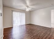 Thumbnail 6 of 23 - A room with wooden floors and a ceiling fan.