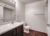 Thumbnail 9 of 23 - A bathroom with a toilet, sink, and mirror.