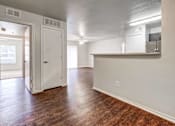 Thumbnail 4 of 23 - A room with a wooden floor and white walls.