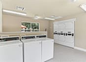 Thumbnail 20 of 23 - A laundry room with washers and dryers.