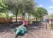 Thumbnail 21 of 23 - A playground with a green slide and a red slide.