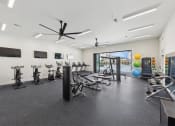 Thumbnail 7 of 20 - a gym with treadmills and other exercise equipment in a building with a window