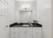 Thumbnail 17 of 20 - a white bathroom with a black counter top and a white sink
