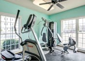 Thumbnail 1 of 23 - A home gym with a treadmill, elliptical trainer, and other exercise equipment.