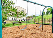 Thumbnail 4 of 23 - A playground with a swing set and a slide.