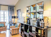 Thumbnail 7 of 23 - A living room with a striped armchair and a striped chair with a table and a mirror.