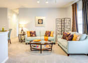 Thumbnail 14 of 23 - A living room with a white couch and a coffee table.