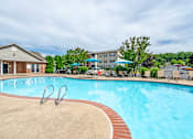 Thumbnail 10 of 23 - A swimming pool with a red brick border and a metal ladder.
