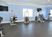 Thumbnail 12 of 36 - A gym with a variety of equipment including treadmills, stationary bikes, and weight machines.