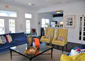 Thumbnail 17 of 36 - A living room with a blue couch, yellow chairs, and a coffee table.