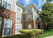 Thumbnail 19 of 28 - A row of townhouses with brick and siding exteriors.