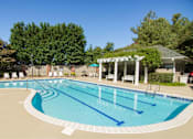 Thumbnail 13 of 28 - A large outdoor swimming pool with a pavilion in the background.