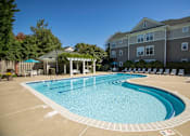 Thumbnail 14 of 28 - A large outdoor swimming pool with a pavilion and sun loungers.