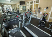 Thumbnail 18 of 28 - A gym with treadmills, elliptical machines, and other exercise equipment.