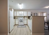 Thumbnail 2 of 40 - A kitchen with white appliances and cabinets.