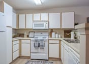 Thumbnail 3 of 40 - A kitchen with white appliances and cabinets.