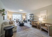 Thumbnail 4 of 40 - A living room with a grey carpet and furniture.