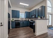 Thumbnail 18 of 40 - A kitchen with dark blue cabinets and a white island.