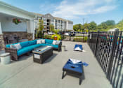 Thumbnail 51 of 64 - A patio area with a sofa, coffee table, and a potted plant.