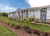 Thumbnail 64 of 64 - Apartment complex with a well-maintained lawn and landscaping.