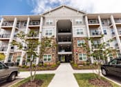 Thumbnail 62 of 64 - A large apartment building with a walkway in front.
