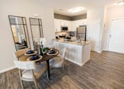 Thumbnail 4 of 64 - A kitchen with a table set for two with a view of the kitchen behind it.