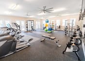 Thumbnail 45 of 64 - A spacious gym with a variety of equipment including treadmills, elliptical machines, and weight machines.
