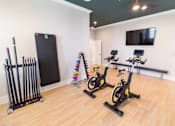 Thumbnail 39 of 64 - A gym with exercise equipment and a TV mounted on the wall.