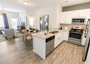 Thumbnail 1 of 64 - A kitchen with white cabinets and a wooden floor.