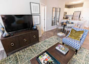 Thumbnail 10 of 64 - A living room with a television and a blue chair.