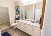 Thumbnail 18 of 64 - A bathroom with a toilet, sink, and mirror.