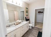Thumbnail 16 of 64 - A bathroom with a sink, toilet, and a mirror.