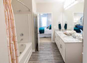 Thumbnail 14 of 64 - A bathroom with a white tub and a wooden floor.