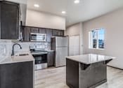 Thumbnail 16 of 25 - A modern kitchen with dark cabinets and stainless steel appliances.