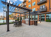 Thumbnail 18 of 26 - A patio with a table and chairs under a pergola.