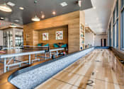 Thumbnail 9 of 26 - A room with a long table and chairs with a bowling alley in the middle.