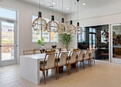 Thumbnail 12 of 53 - A modern dining room with a long table and chairs.