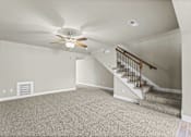 Thumbnail 30 of 47 - A room with a carpeted floor and a staircase.