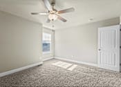 Thumbnail 11 of 47 - A room with a ceiling fan and a door.