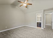 Thumbnail 36 of 47 - A room with a ceiling fan and carpeted floor.