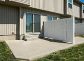 Thumbnail 7 of 47 - Peculiar, MO, Townhomes - Bradley’s Crossing - Outdoor Patio with Yard, Concrete Flooring, White Fence, and Grass Area.
