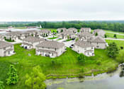 Thumbnail 14 of 47 - A bird's eye view of a residential area with houses and a pond.